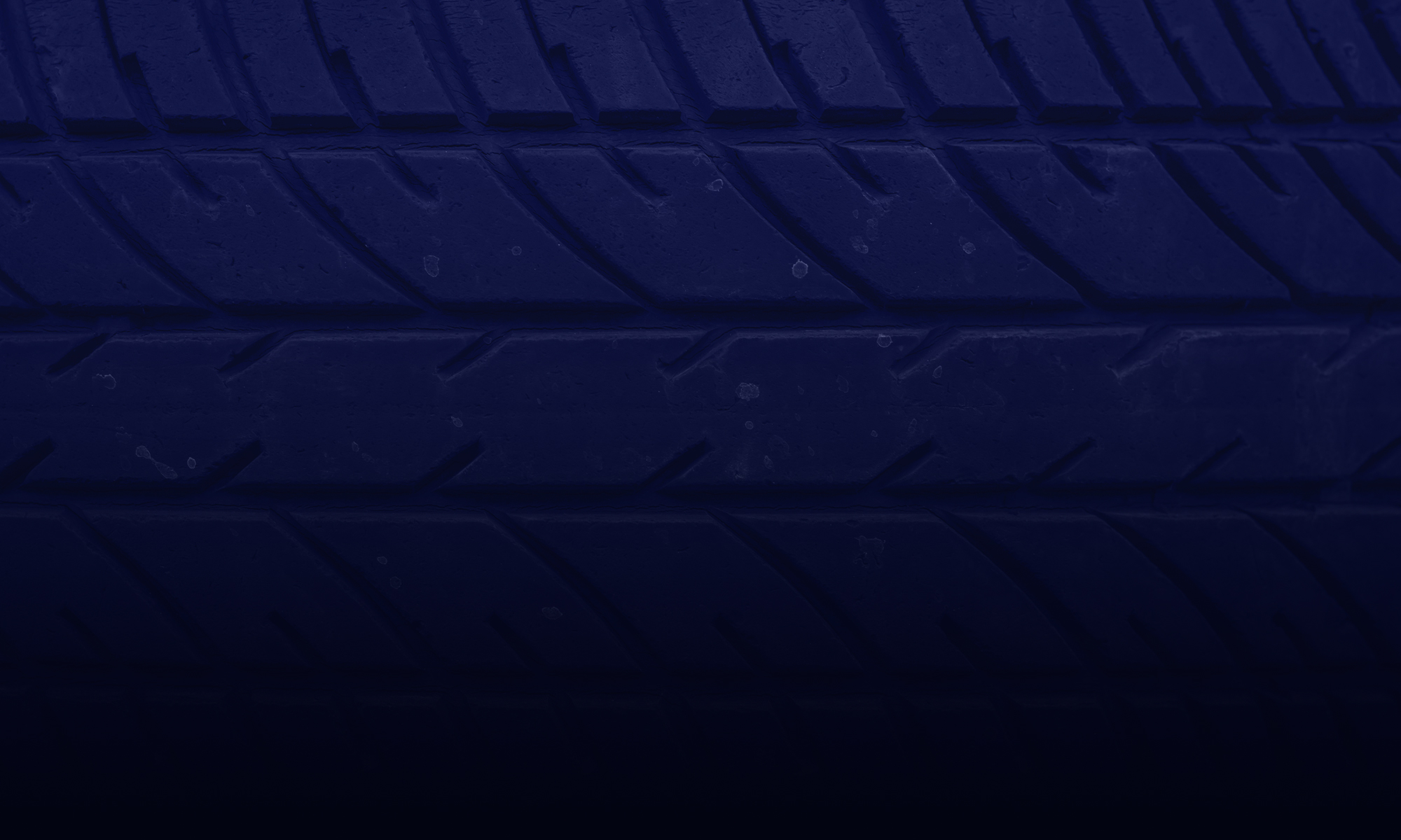 Close-up of car tire tread pattern, showcasing detailed grooves for traction and performance.