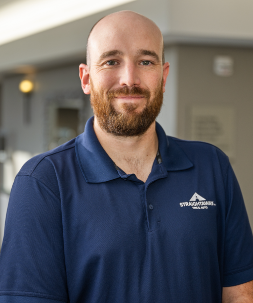 Smiling Man In Blue Polo Shirt Standing Indoors, Looking At The Camera.