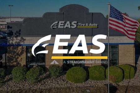 Exterior view of EAS Tire & Auto store with American flag, daylight scene.