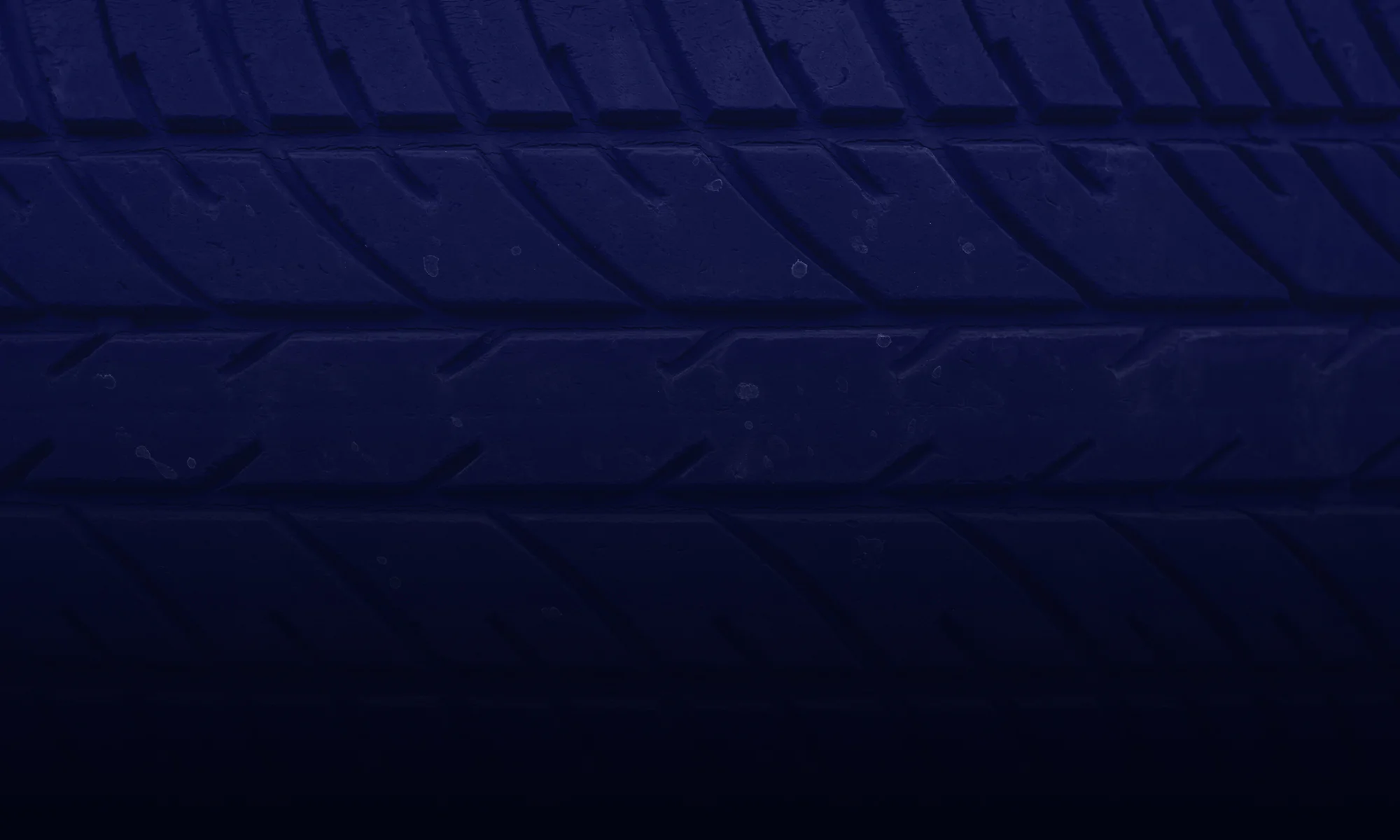 Close-up of car tire tread pattern, showcasing detailed grooves for traction and performance.