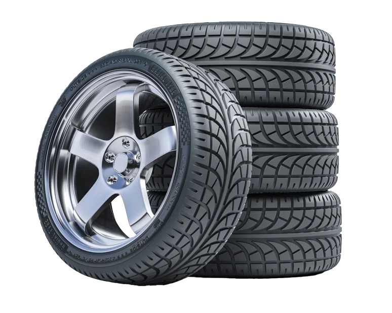 Stack of four new car tires with alloy rims, showcasing tread pattern and shiny metal finish.